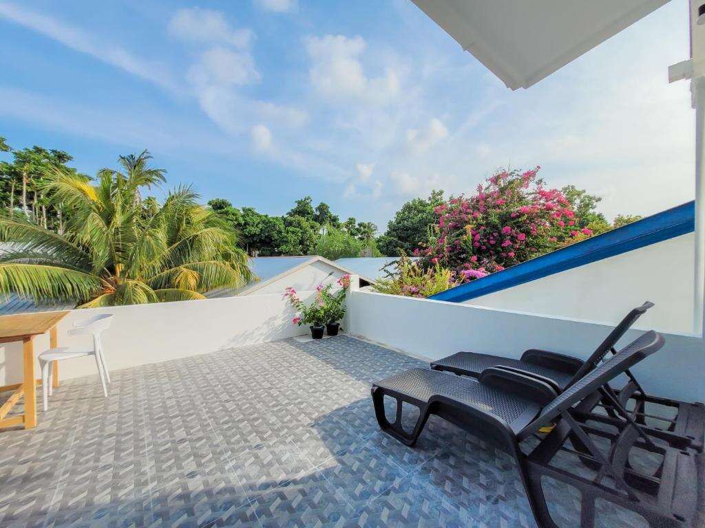 Upper terrace with sun loungers and tropical flowers